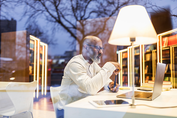 man using laptop in library